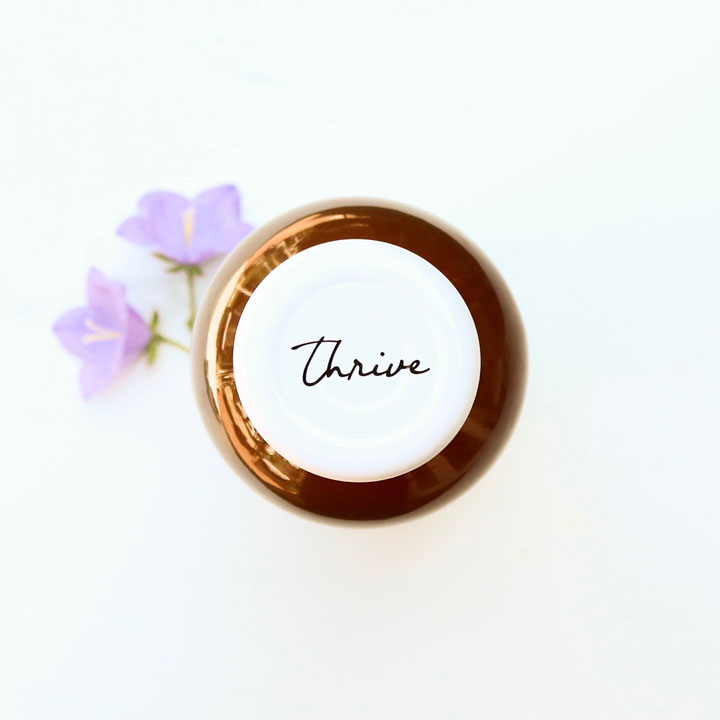 thrive remedies bottle lid next to purple flowers